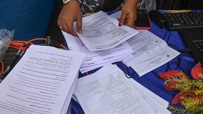 Election Commission officials assist voters at a help desk camp for the Special Intensive Revision (SIR) of Electoral Rolls, in Sonagachi, Kolkata. (PTI)