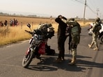 Soldiers check motorcycle drivers after organized crime burned vehicles to block roads 