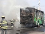 Firefighters work to extinguish flames from a vehicle in Guadalajara, Mexico
