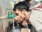 TOPSHOT - An Indian labrourer drinks water at a public water fountain on a hot summer day in the old quarters of New Delhi on May 1, 2018. / AFP PHOTO / Sajjad HUSSAIN (AFP)