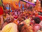 Revellers celebrate Lathmar Holi, the Hindu spring festival of colours, next to a wall mural of Lord Krishna in Barsana on Wednesday (AFP)