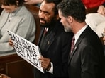 US Representative Al Green, a democrat from Texas, holds a sign reading "Black People Aren't Apes" as he is escorted out during US President Donald Trump's State of the Union address in the House Chamber of the US Capitol in Washington, DC.