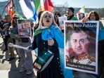 Protestors react and hold portraits of Reza Pahlavi during a demonstration organised by members of the Iranian diaspora outside the United Nations offices during new round of talks between the United States and Iran