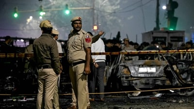 Police personnel stand beside charred vehicles at the blast site near the Red Fort in November. (File photo.) (AFP) Police personnel stand beside charred vehicles at the blast site near the Red Fort in November. (File photo.) (AFP)