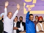 AAP national convener Arvind Kejriwal (in blue) and party leader Manish Sisodia (L) wave to crowd during an event