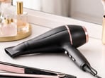 A sleek hair dryer and straightener rest on a vanity, ready to create smooth, glossy styles for daily wear.