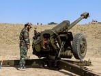 Taliban security personnel stand next to an artillery gun near the border area in the Jaji Maydan district of Khost province on February 27, 2026 
