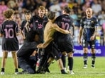 A fan who got onto the field grabs Inter Miami's Lionel Messi. 