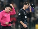 New Zealand's captain Mitchell Santner (R) reacts after the loss against England. 