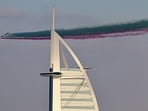 The Al-Fursan National Aerobatic team performs a commemorative flypast over the Dubai coastline and the Burj Al-Arab 