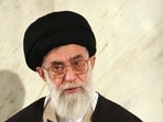 Iran's Supreme Leader Ayatollah Ali Khamenei looks up as he holds the Quran during a ceremony in Tehran