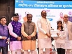 Uttar Pradesh deputy chief minister Brajesh Pathak hands over a vaccination certificate in Lucknow on Saturday. (SOURCED)
