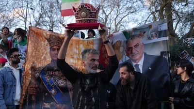 A protester holds a crown in London, Saturday, Feb. 28, 2026 after U.S. and Israeli forces carried out a series of strikes on Iran on Saturday morning. (AP Photo/Alastair Grant) (AP) A protester holds a crown in London, Saturday, Feb. 28, 2026 after U.S. and Israeli forces carried out a series of strikes on Iran on Saturday morning. (AP Photo/Alastair Grant) (AP)