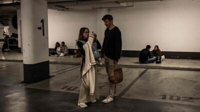 Two people tie the hair of their baby as they take shelter in a underground parking in Tel Aviv on February 28, 2026. The Israeli military said its strikes on Iran, in coordination with the United States, targeted dozens of military sites and followed months of joint planning between the allies. (Photo by JOHN WESSELS / AFP) (AFP) Two people tie the hair of their baby as they take shelter in a underground parking in Tel Aviv on February 28, 2026. The Israeli military said its strikes on Iran, in coordination with the United States, targeted dozens of military sites and followed months of joint planning between the allies. (Photo by JOHN WESSELS / AFP) (AFP)