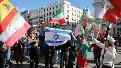 Anti-Iranian regime protesters hold an Israeli flag while they wave the Iranian flag before the 1979 revolution with the Lion and Sun emblems and hold portraits of son of last shah of Iran and now key opposition figure Mohammad Reza Pahlavi as they gather at Puerta del Sol Square, in Madrid, on February 28, 2026. The United States and Israel launched strikes against Iran today, sending columns of smoke rising over Tehran as the Islamic republic retaliated with barrages of missiles across the region. (Photo by Thomas COEX / AFP) (AFP) Anti-Iranian regime protesters hold an Israeli flag while they wave the Iranian flag before the 1979 revolution with the Lion and Sun emblems and hold portraits of son of last shah of Iran and now key opposition figure Mohammad Reza Pahlavi as they gather at Puerta del Sol Square, in Madrid, on February 28, 2026. The United States and Israel launched strikes against Iran today, sending columns of smoke rising over Tehran as the Islamic republic retaliated with barrages of missiles across the region. (Photo by Thomas COEX / AFP) (AFP)