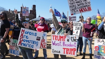 People hold signs as they take part in a "March 4 Democracy" protest in Washington, DC, on February 28, 2026. The United States and Israel launched what the latter called a "decisive and unprecedented" campaign against Iran, which retaliated with a barrage of missiles that sent residents running for cover on Saturday in cities across the Middle East. (Photo by Ken Cedeno / AFP) (AFP) People hold signs as they take part in a "March 4 Democracy" protest in Washington, DC, on February 28, 2026. The United States and Israel launched what the latter called a "decisive and unprecedented" campaign against Iran, which retaliated with a barrage of missiles that sent residents running for cover on Saturday in cities across the Middle East. (Photo by Ken Cedeno / AFP) (AFP)