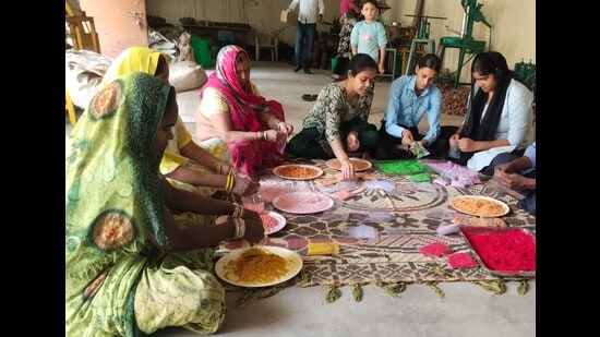 Women associated with self-help groups making eco-friendly abeer and gulal from Palash flowers in Prayagraj. (HT photo)