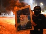 A protester holds an image of Iran's Supreme Leader Ayatollah Ali Khamenei