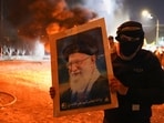 A protester holds an image of Iran's Supreme Leader Ayatollah Ali Khamenei