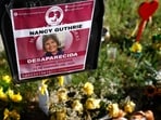TUCSON, ARIZONA - FEBRUARY 27: Flowers and signs are seen in a makeshift memorial in front of the home of Nancy Guthrie on February 27, 2026 in Tucson, Arizona. (Photo by JUSTIN SULLIVAN / GETTY IMAGES NORTH AMERICA / Getty Images via AFP)