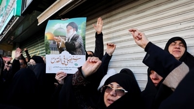 A woman holds a poster with the picture of Iran's Supreme Leader Ayatollah Ali Khamenei as people gather after Khamenei was killed in Israeli and U.S. strikes on Saturday, in Tehran, Iran, March 1, 2026. (via REUTERS)