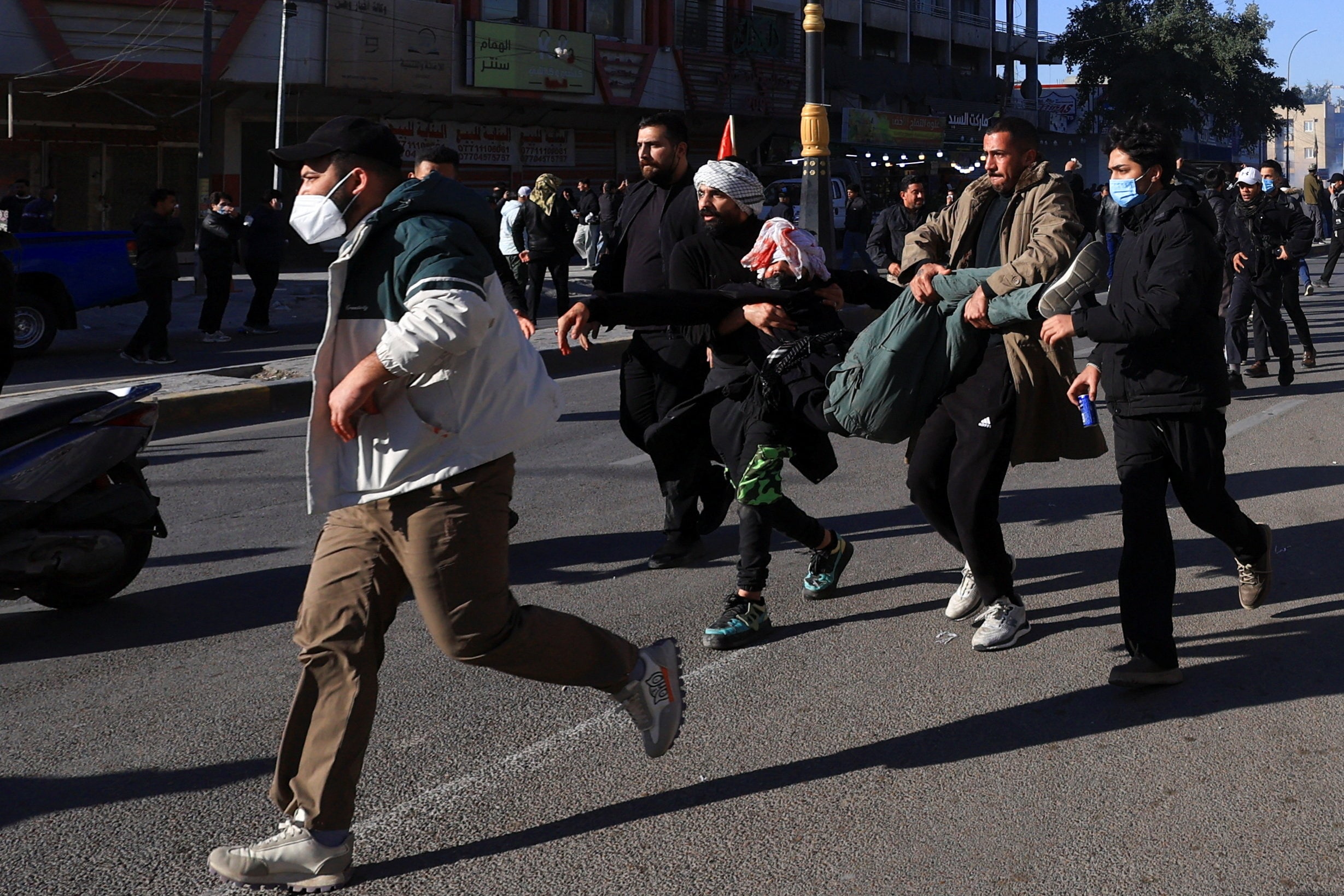 Protesters supporting Iraqi Shi'ite armed groups gathered near the entrance of the Green Zone and attempted to move toward the U.S. embassy after the killing of Iran's Supreme Leader Ayatollah Ali Khamenei, carry an injured person as riot police deployed irritants to block their advance, in Baghdad, Iraq, March 1, 2026. REUTERS/Thaier Al-Sudani (REUTERS)