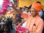 Uttar Pradesh chief minister Yogi Adityanath showering petals on devotees during the Bhakt Prahlad Shobha Yatra in Gorakhpur on Monday. (HT)