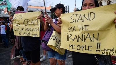 Activists hold placards during a rally condemning the US-Israeli strikes on Iran at a park in Quezon City, suburban Manila on March 2, 2026. (Photo by Ted ALJIBE / AFP) (AFP)