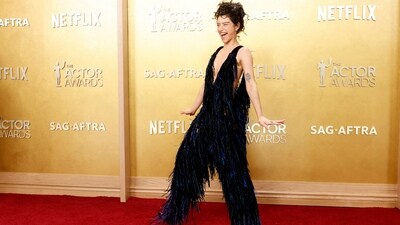 Marty Supreme actor Odessa A'zion stole the spotlight in a whimsical frilly ensemble. She looked radiant on the red carpet in a shaggy deep blue jumpsuit with upper thigh cut-outs, covered in fringes all over. The look was paired with a messy up-do and dewy makeup. (REUTERS/Caroline Brehman)