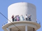 Members of the ETT TET Pass Teachers’ Union atop a water tank protesting against the Punjab government in Dirba on Tuesday. (HT Photo)