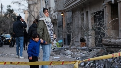 A woman with her child looks at the aftermath of an Israeli and the U.S. strike on a police station, amid the U.S.-Israel conflict with Iran, in Tehran, Iran, March 2, 2026. Majid Asgaripour/WANA (West Asia News Agency) via REUTERS ATTENTION EDITORS - THIS PICTURE WAS PROVIDED BY A THIRD PARTY     TPX IMAGES OF THE DAY (via REUTERS)
