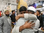 Indian passengers reunite with their family members as they arrive safely from a flight via Dubai amid the international tensions in the Gulf region at Indira Gandhi International Airport, in New Delhi.