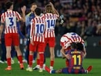 Atletico Madrid's Johnny Cardoso hugs Barcelona's Raphinha.