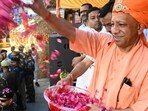 Uttar Pradesh chief minister Yogi Adityanath showering petals on devotees during the Bhakt Prahlad Shobha Yatra in Gorakhpur on Monday. (HT)