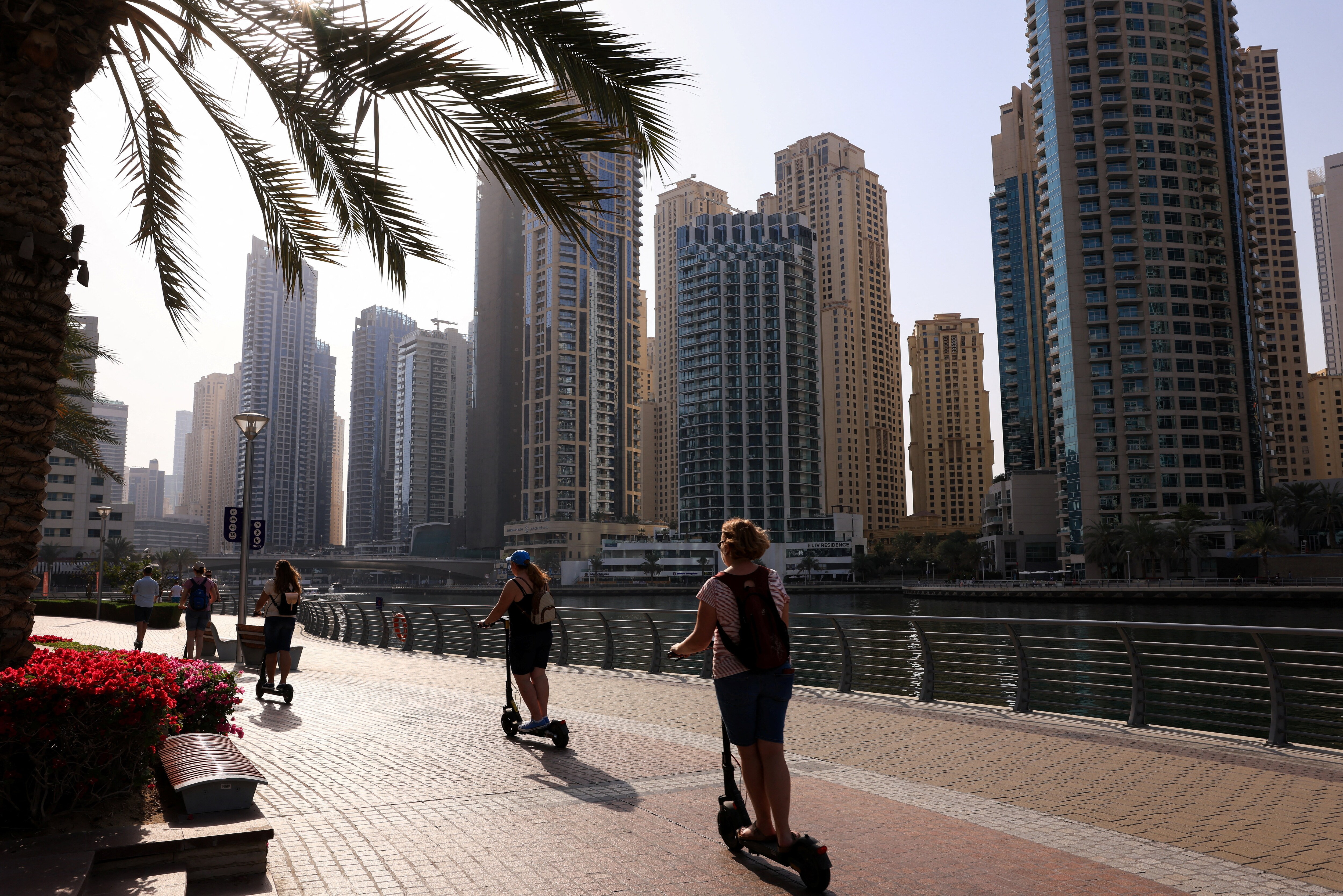 People ride scooters in Dubai Marina, amid the US-Israeli conflict with Iran, in Dubai (REUTERS)