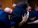 WASHINGTON, DC - MARCH 4: A protester dressed in a military uniform gets stuck in a door, injuring his arm, as Sen. Tim Sheehy (R-MT) (L) and U.S. Capitol Police officers attempt to remove him from a Senate Armed Services Subcommittee hearing on Capitol Hill on March 4, 2026 in Washington, DC. The Subcommittee on Readiness and Management Support is holding a hearing to examine the current readiness of the Joint Force. (Photo by Andrew Harnik / GETTY IMAGES NORTH AMERICA / Getty Images via AFP)