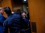 WASHINGTON, DC - MARCH 4: A protester dressed in a military uniform gets stuck in a door, injuring his arm, as Sen. Tim Sheehy (R-MT) (L) and U.S. Capitol Police officers attempt to remove him from a Senate Armed Services Subcommittee hearing on Capitol Hill on March 4, 2026 in Washington, DC. (Photo by Andrew Harnik / GETTY IMAGES NORTH AMERICA / Getty Images via AFP)