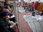 Electoral officials sit on the floor as they count votes at the counting centre after voting ended in Nepal's general election in Kathmandu on March 5