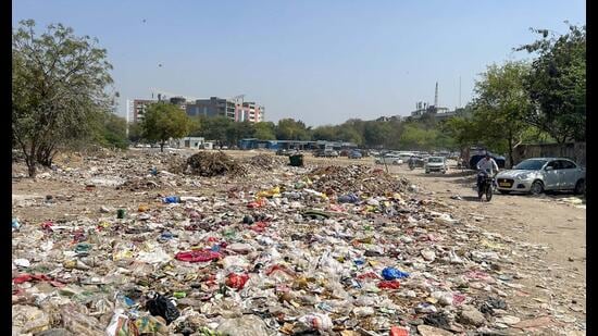 Heaps of garbage dumped in a vacant plot near the building as seen o n Friday. (Parveen Kumar/HT)