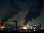 A tall plume of smoke billows from a fire next to Azadi Tower (C) following strikes near Mehrabad International Airport in Tehran on March 7, 2026. 