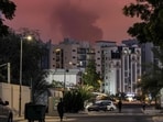 Bystanders watch as a plume of black smoke rises from the port of Fujairah in the gulf emirate of Fujairah, UAE on March 4