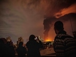 Residents look on and take pictures as flames and smoke rise from an oil storage facility struck as attacks hit the city during the U.S.–Israeli military campaign in Tehran, Iran, Saturday, March 7, 2026. Residents look on and take pictures as flames and smoke rise from an oil storage facility struck as attacks hit the city during the U.S.–Israeli military campaign in Tehran, Iran, Saturday, March 7, 2026.