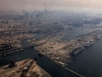 Dubai Abu Dhabi news highlights: A view from inside a stained window of an airplane shows Dubai International Airport, with the Burj Khalifa in the background, amid the U.S.-Israeli conflict with Iran, in Dubai, United Arab Emirates, March 8, 2026.
