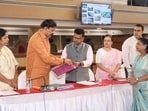 Municipal commissioner Naval Kishore Ram on Monday presented the draft budget to standing committee chairman Shreenath Bhimale in the presence of Mayor Manjusha Nagpure (Left). (HT)