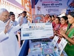Bihar chief minister Nitish Kumar presents cheques to Jivika Didi during his Samriddhi Yatra at Supaul in Bihar. (HT Photo)