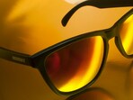 Classic Wayfarer sunglasses resting in sunlight, showing the bold trapezoid frame and thick temples that shaped decades of eyewear style.(pexels.com)