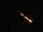 Trails of a cluster missile fired from Iran cross the sky over Tel Aviv, Israel, Wednesday.