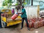 Delivery personnel transfer LPG cylinders amid a panic among people related to LPG supply shortage