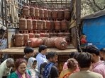 People wait to refill their LPG Cylinders, in New Delhi on Thursday.