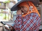 Laaiad Namneewong, 62, reacts as she looks at a photo of Sommai Butdee's nephew, Panupong Muentan, 27, an engine room mechanic and one of three Thai crew members who remain missing after a Thai ship was hit by unknown projectiles in the Strait of Hormuz.